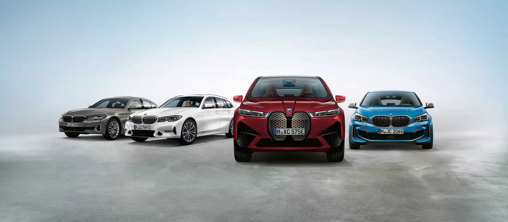 Vier neue BMW Modelle verschiedener Farben und Typen in einem Studio.