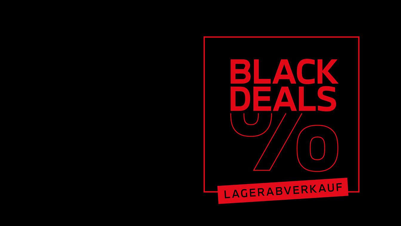 Das Bild ist ein auffälliges, hochkontrastreiches Werbebanner, das auf einem schwarzen Hintergrund basiert. In der rechten Hälfte dominiert eine Grafik in leuchtendem Rot, die von einem quadratischen Rahmen eingefasst wird. Im Zentrum der Grafik steht in großen, roten Blockbuchstaben der Schriftzug "BLACK DEALS", akzentuiert durch ein sehr großes, grafisch dargestelltes Prozentzeichen (%). Am unteren Rand der roten Grafik signalisiert ein separates, rotes Banner mit hellem Text zusätzlich "LAGERABVERKAUF". Das Gesamtbild ist eine klare und aggressive Darstellung einer Rabattaktion oder eines Schlussverkaufs.