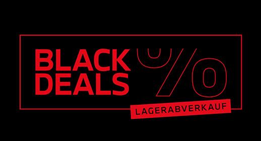 Dieses Bild ist ein horizontales Werbebanner, das auf einem schwarzen Hintergrund basiert und durch die Farbe Rot akzentuiert wird. Die gesamte Komposition wird von einem rechteckigen, roten Rahmen umgeben. Innerhalb dieses Rahmens dominiert auf der linken Seite in großen, roten Blockbuchstaben der zweizeilige Schriftzug "BLACK DEALS". Rechts davon ist ein sehr großes, grafisch angedeutetes Prozentzeichen (%) in dünnen roten Linien zu sehen. Am unteren rechten Rand des Rahmens befindet sich ein rotes, rechteckiges Feld mit dem Text "LAGERABVERKAUF" in kleineren, weißen oder hellen Buchstaben. Das Bild ist eine klare und fokussierte Ankündigung für eine "Black Deals"-Veranstaltung im Rahmen eines Lagerabverkaufs.