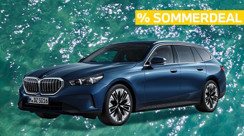 Ein dunkelblauer BMW 520i Touring steht auf einem leuchtend türkisen, leicht bewegten Wasserhintergrund. Das Fahrzeug ist leicht von vorne links aufgenommen, wodurch die Frontpartie mit dem markanten Kühlergrill und die gesamte linke Fahrzeugseite gut zu erkennen sind. Oben rechts im Bild ist ein gelber Balken mit der Aufschrift „% SOMMERDEAL“ in Großbuchstaben platziert. Der Kombi wirkt elegant und sportlich zugleich, mit modernen Felgen